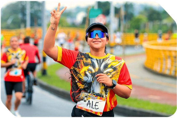 young woman in a bright red and yellow shirt running a race and flashing a peace sign young woman in a bright red and yellow shirt running a race and flashing a peace sign